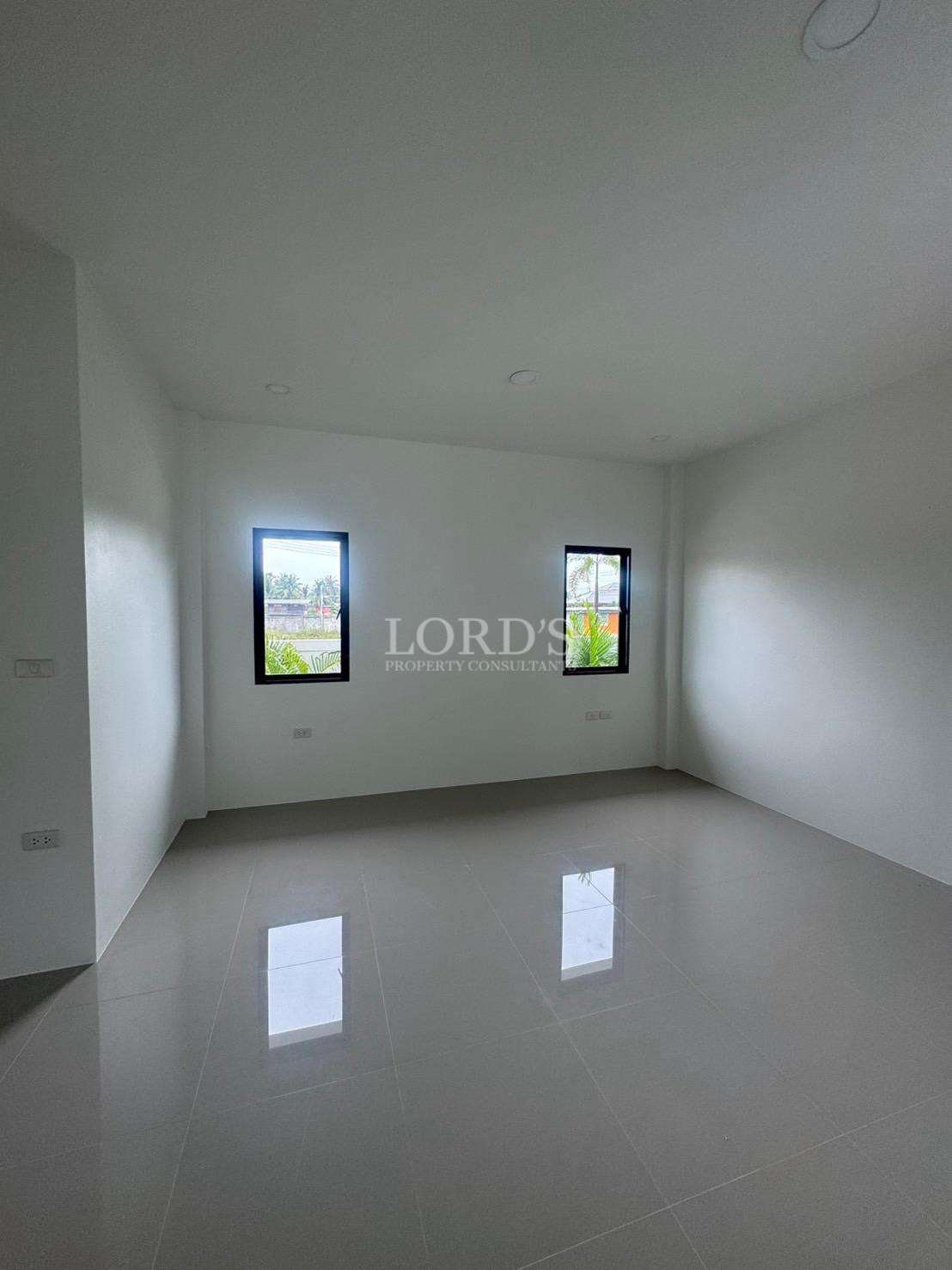 Empty modern bedroom with glossy tiled floor and two windows