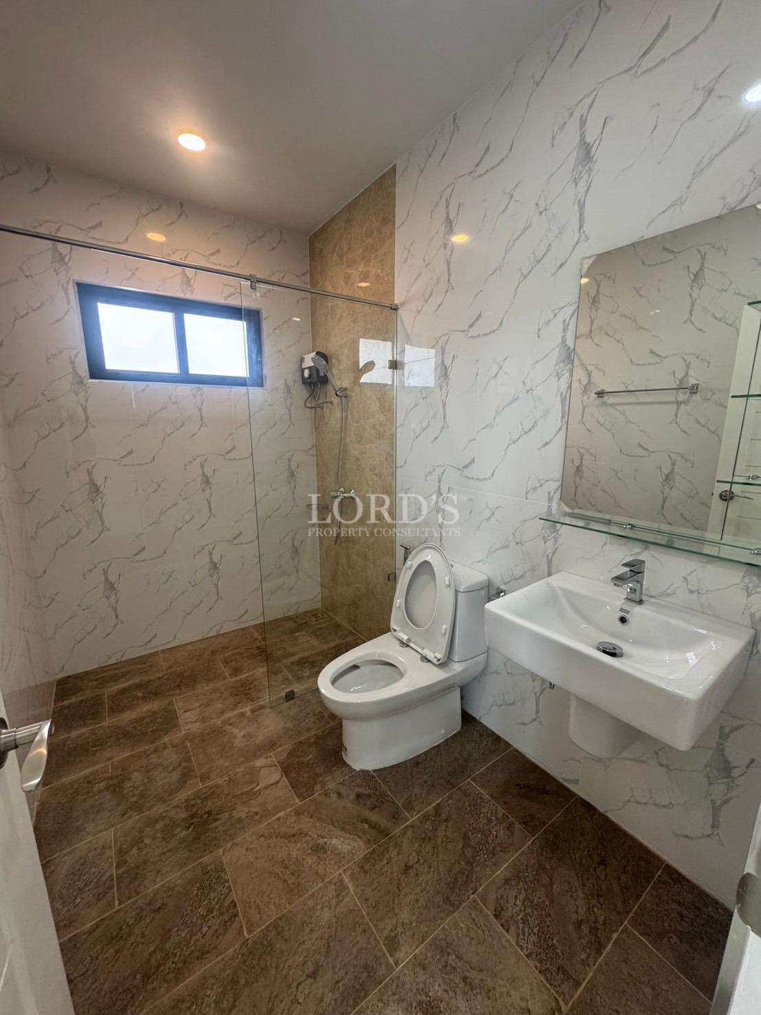 Modern bathroom with walk-in glass shower, toilet, and wall-mounted sink