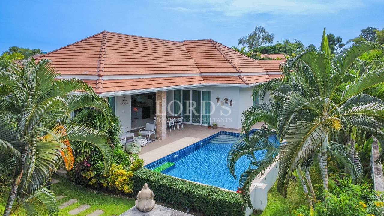 Tropical villa exterior with private pool and tiled roof
