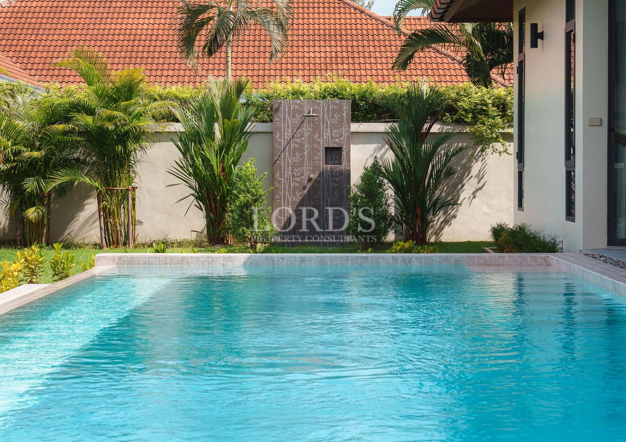 Clear pool surrounded by lush greenery