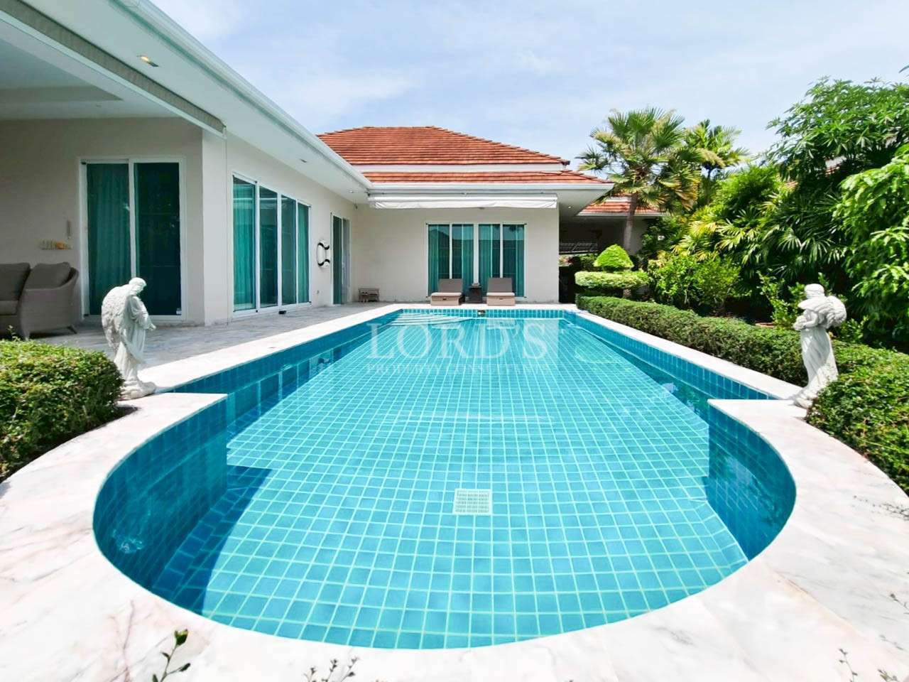 Luxury private swimming pool with blue mosaic tiles at a modern single-story villa.