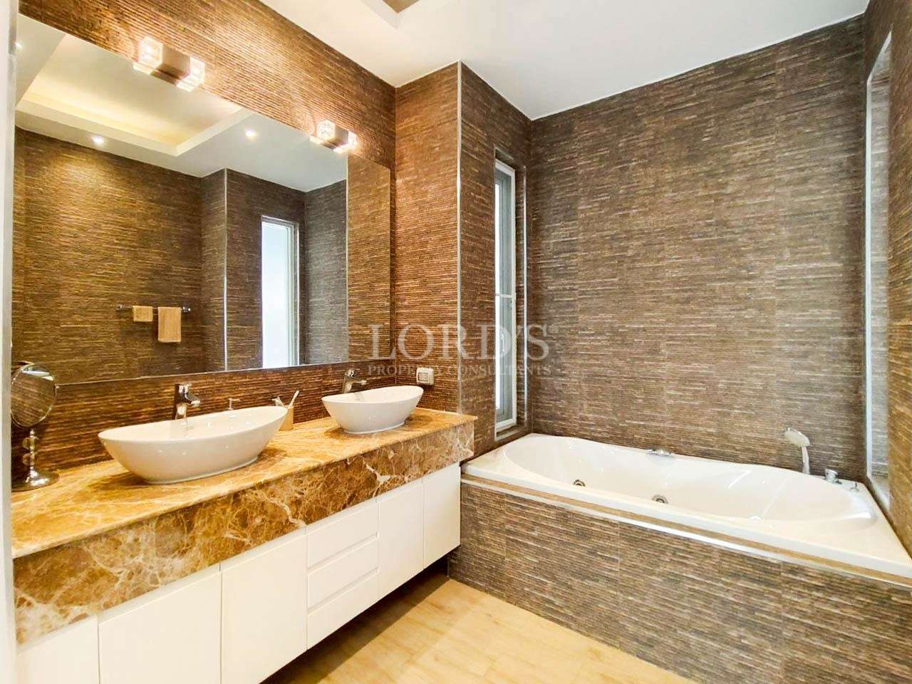 Luxury bathroom with double vessel sinks, marble countertop, and built-in bathtub