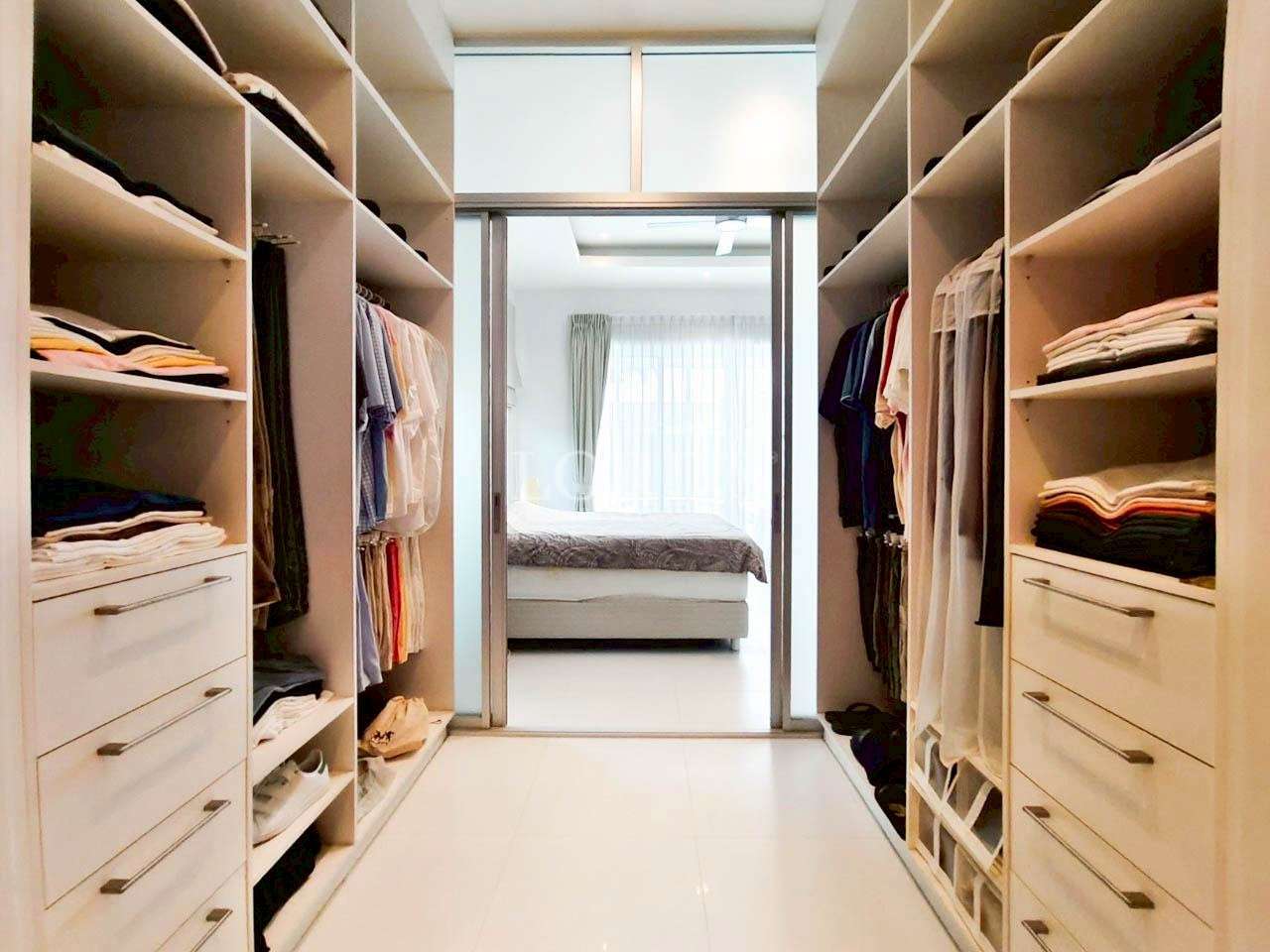 Walk-in closet with built-in shelves, hanging clothes, and drawer storage