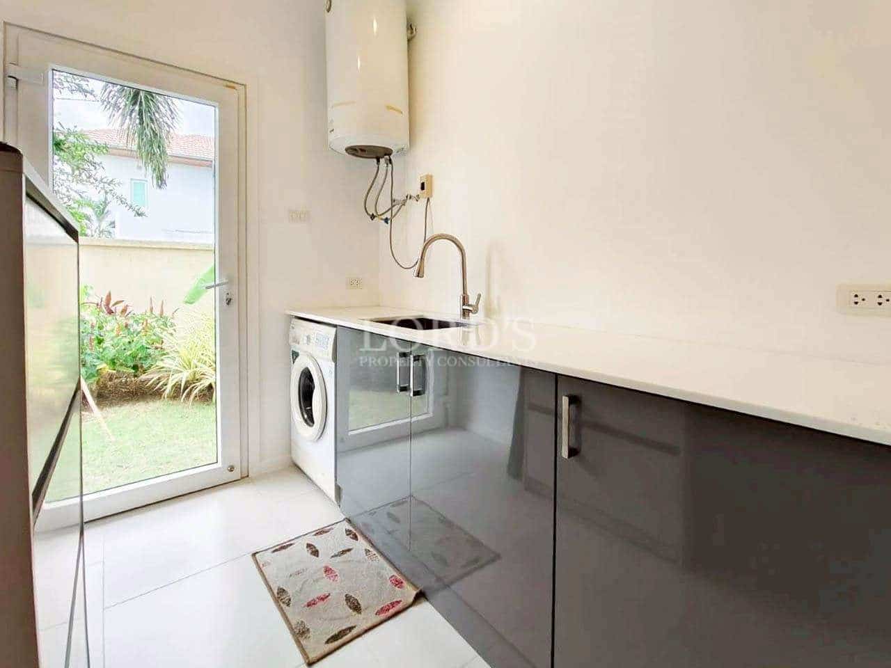 Modern laundry and utility room with washing machine, sink, and garden access