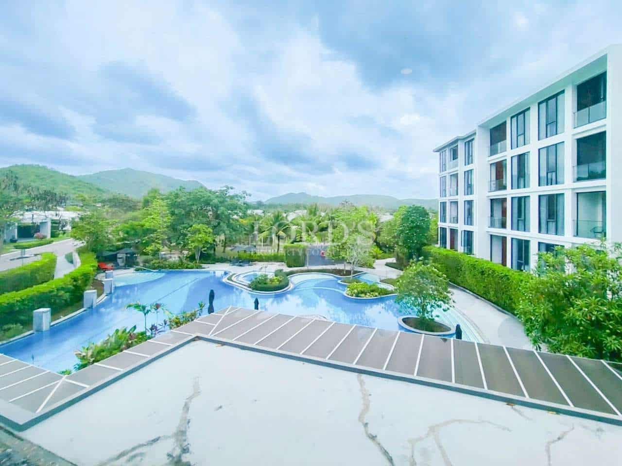 Modern residential complex with resort-style swimming pool and landscaped gardens.
