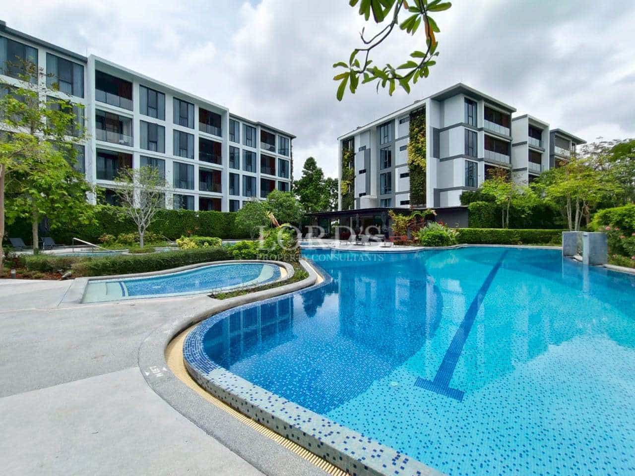 LINE_ALBUM_Sansara_250403_56 Modern condominium buildings with a resort-style swimming pool and landscaped surroundings.