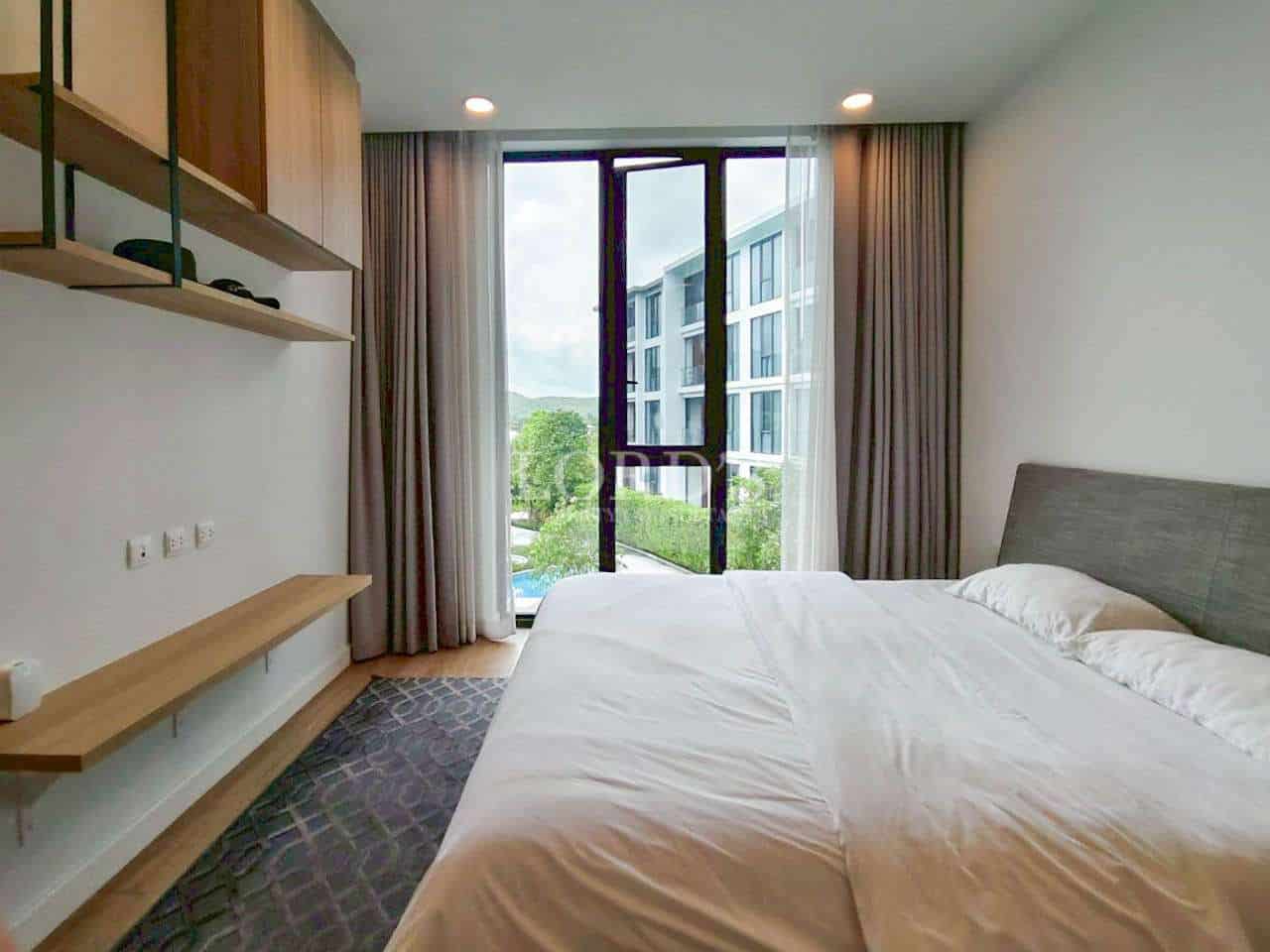 Modern bedroom with double bed, wall shelves, and large window view.