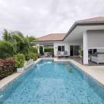 Modern poolside villa with greenery.