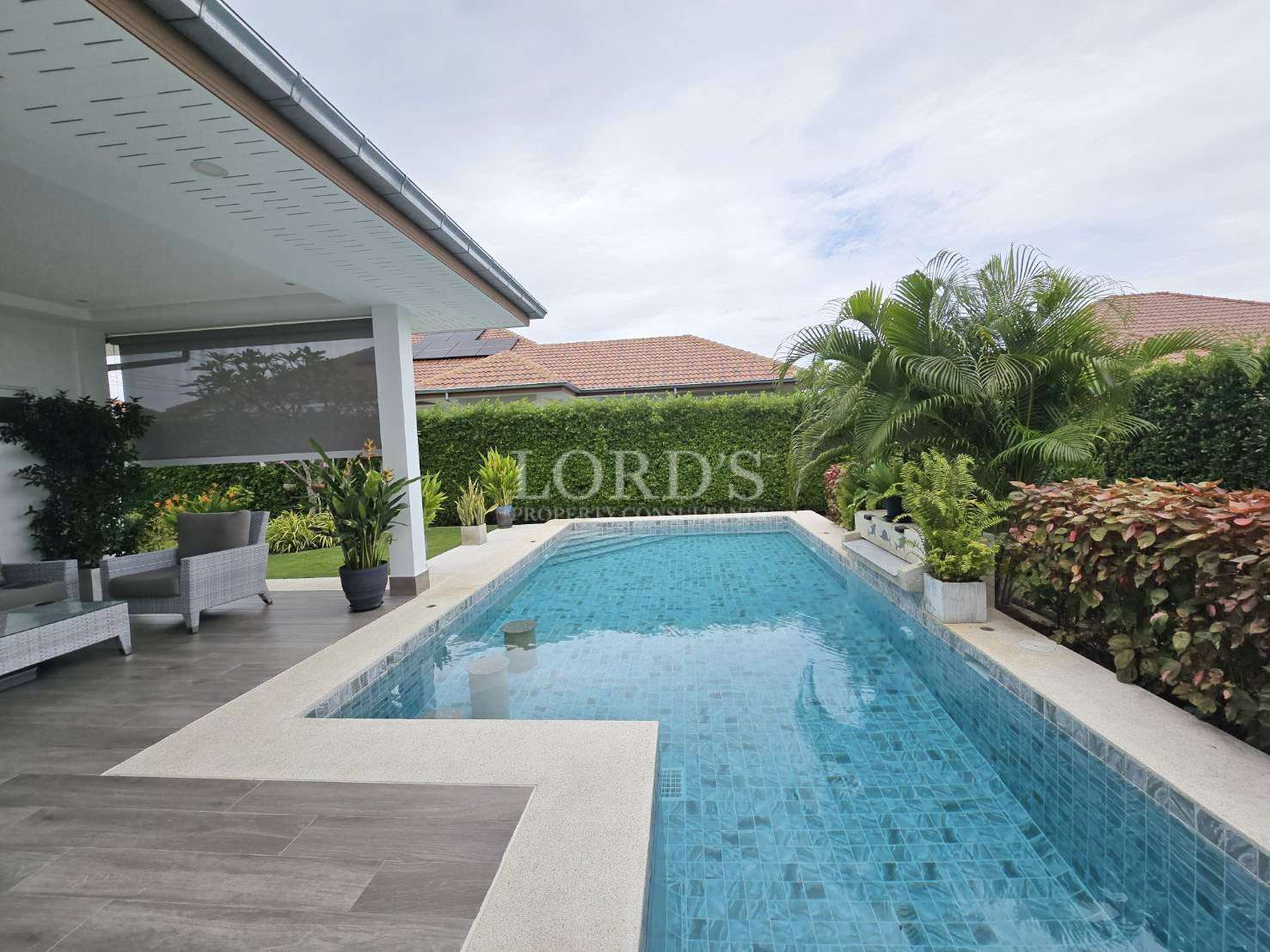 Modern poolside with lush greenery.