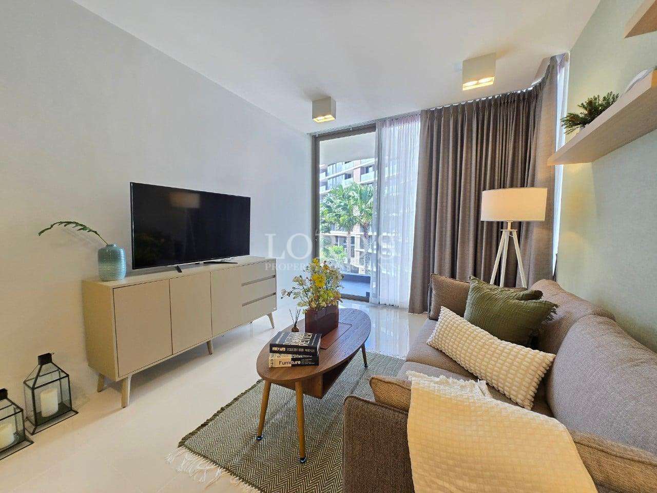 Modern living room with sofa, TV cabinet, coffee table, and balcony view through glass doors.