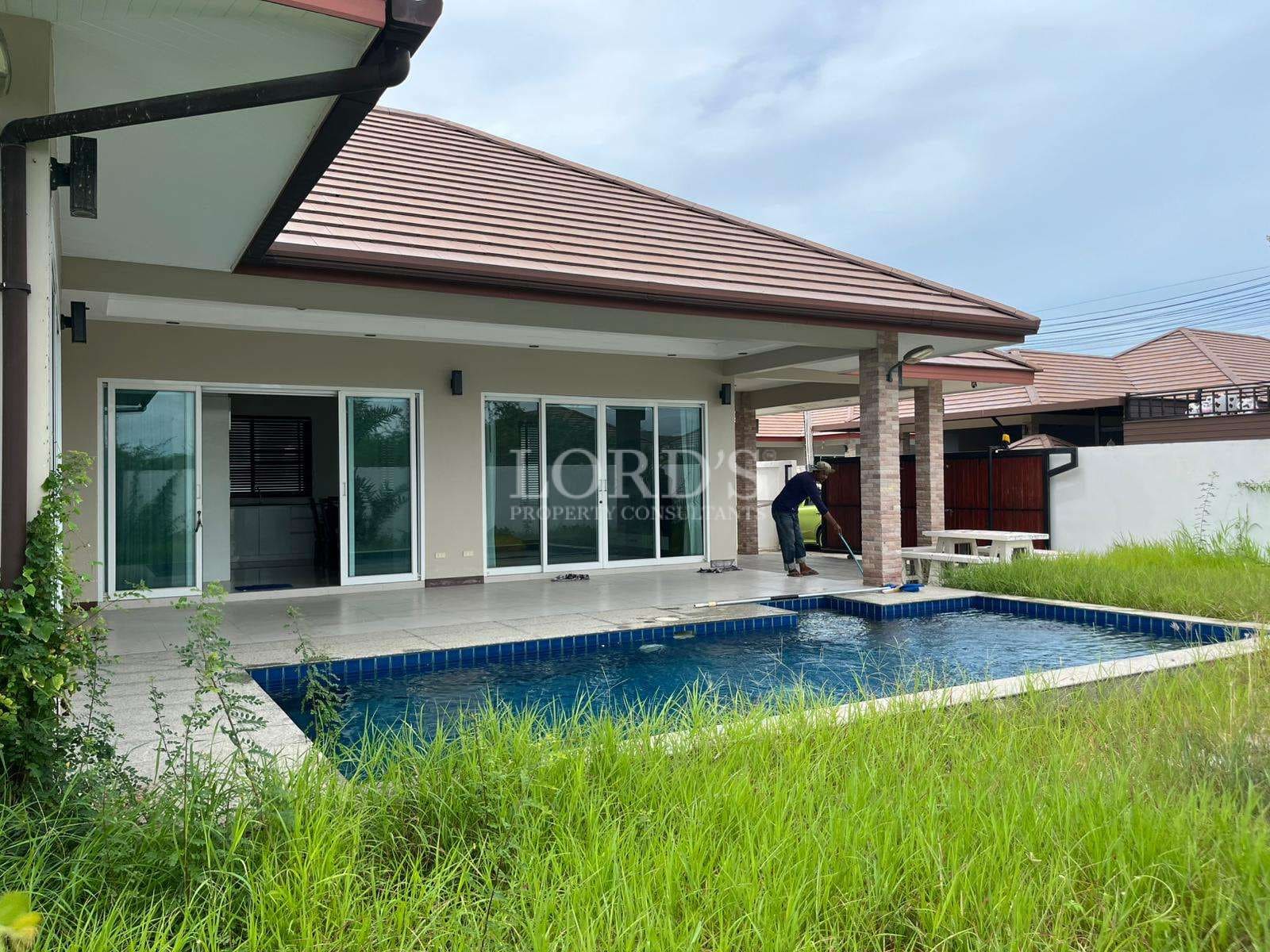 House with pool and overgrown grass