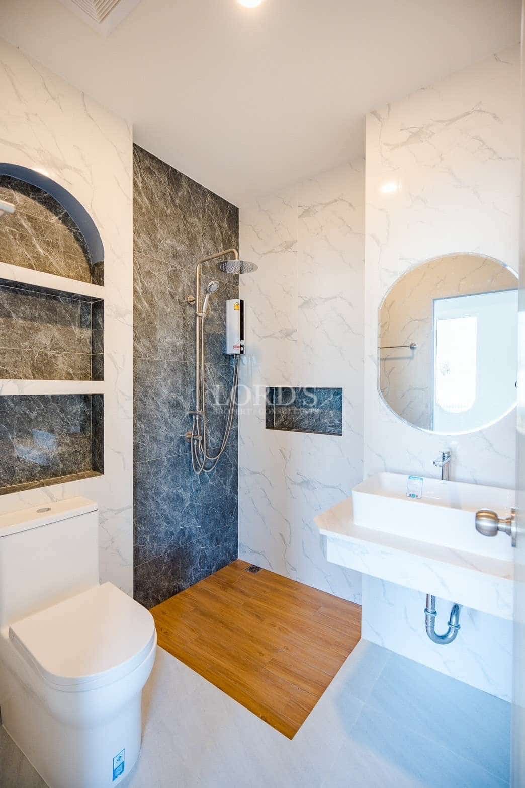 Modern marble bathroom with walk-in shower, wooden floor base, and round mirror vanity