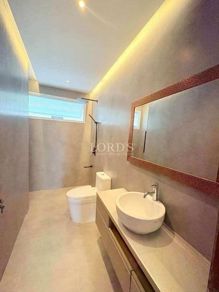 Modern minimalist bathroom with vanity sink, toilet, and walk-in shower