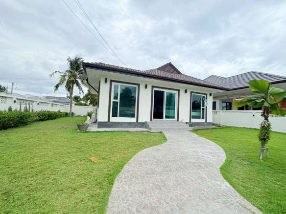 Modern single-story house with green lawn and curved walkway
