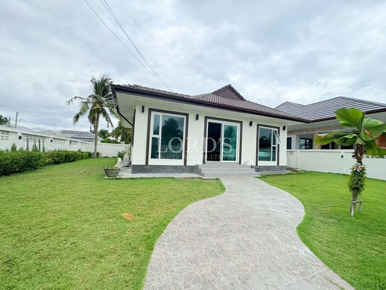 Modern single-story house with green lawn and curved walkway