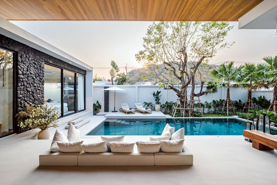 Luxury poolside lounge area with modern seating, private swimming pool, and tropical garden.
