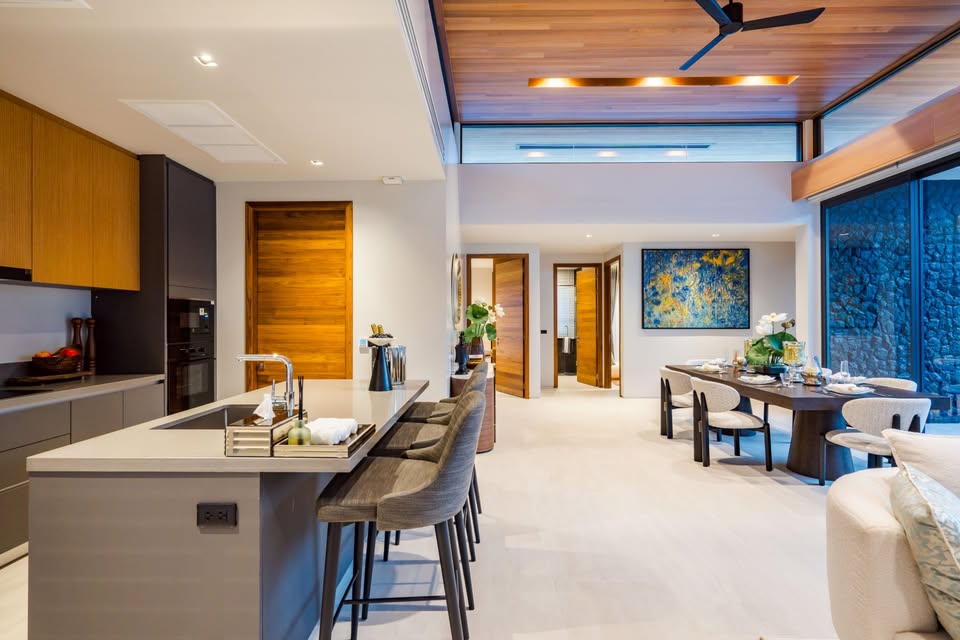 Modern open-plan kitchen and dining area with kitchen island, wooden ceiling, and contemporary interior design.