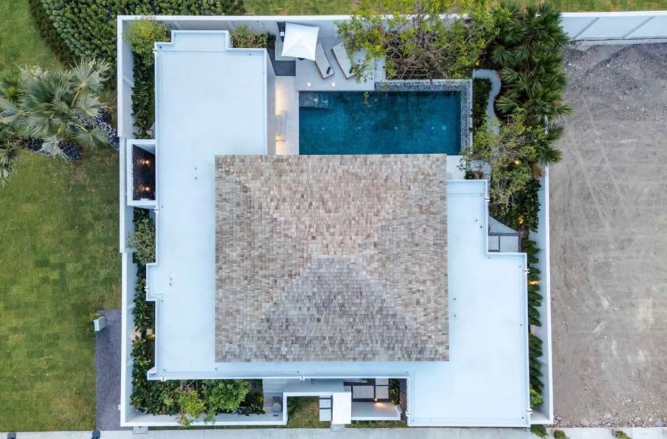 Aerial view of a modern luxury villa with private swimming pool, landscaped garden, and contemporary architecture.