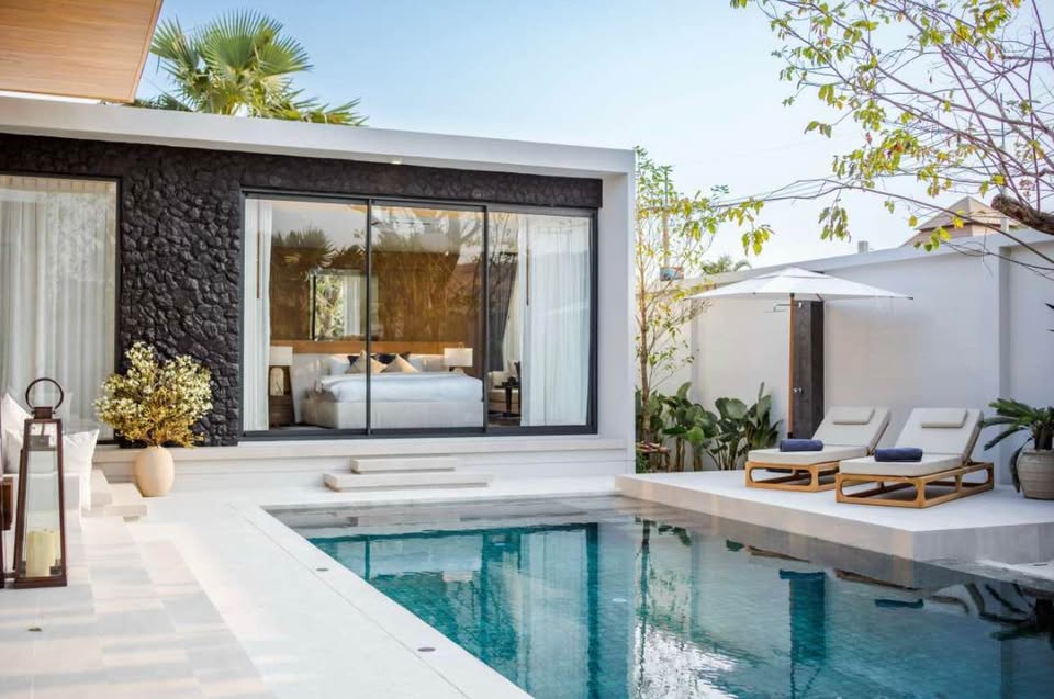 Luxury pool villa exterior with private swimming pool, sun loungers, and modern bedroom with glass doors.