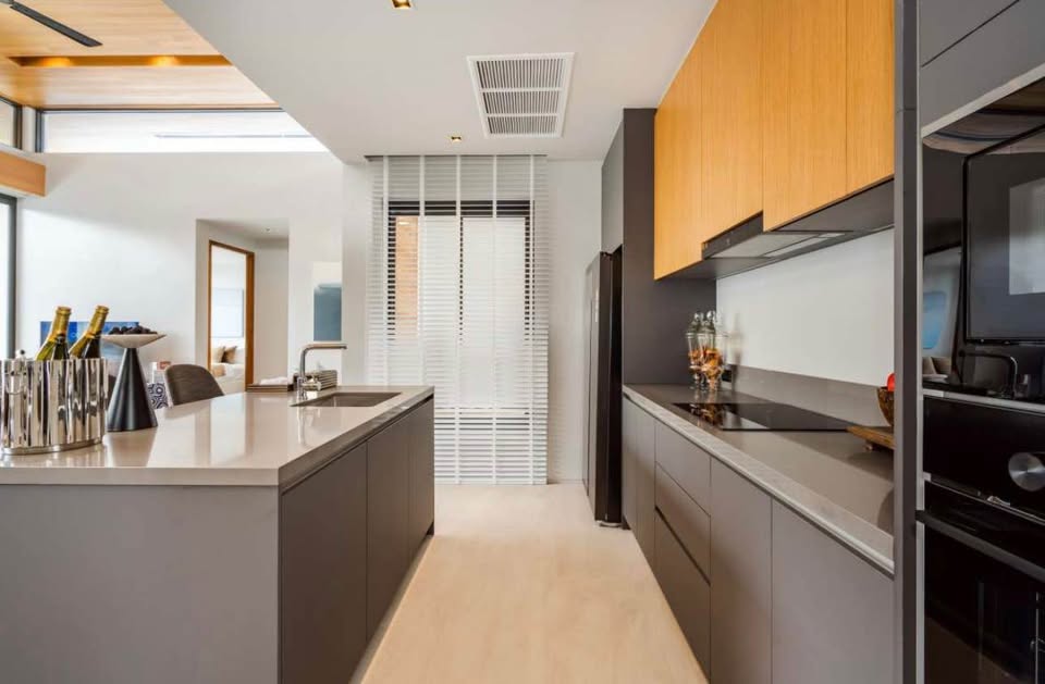 Modern kitchen interior with sleek cabinets, kitchen island, built-in appliances, and minimalist design.