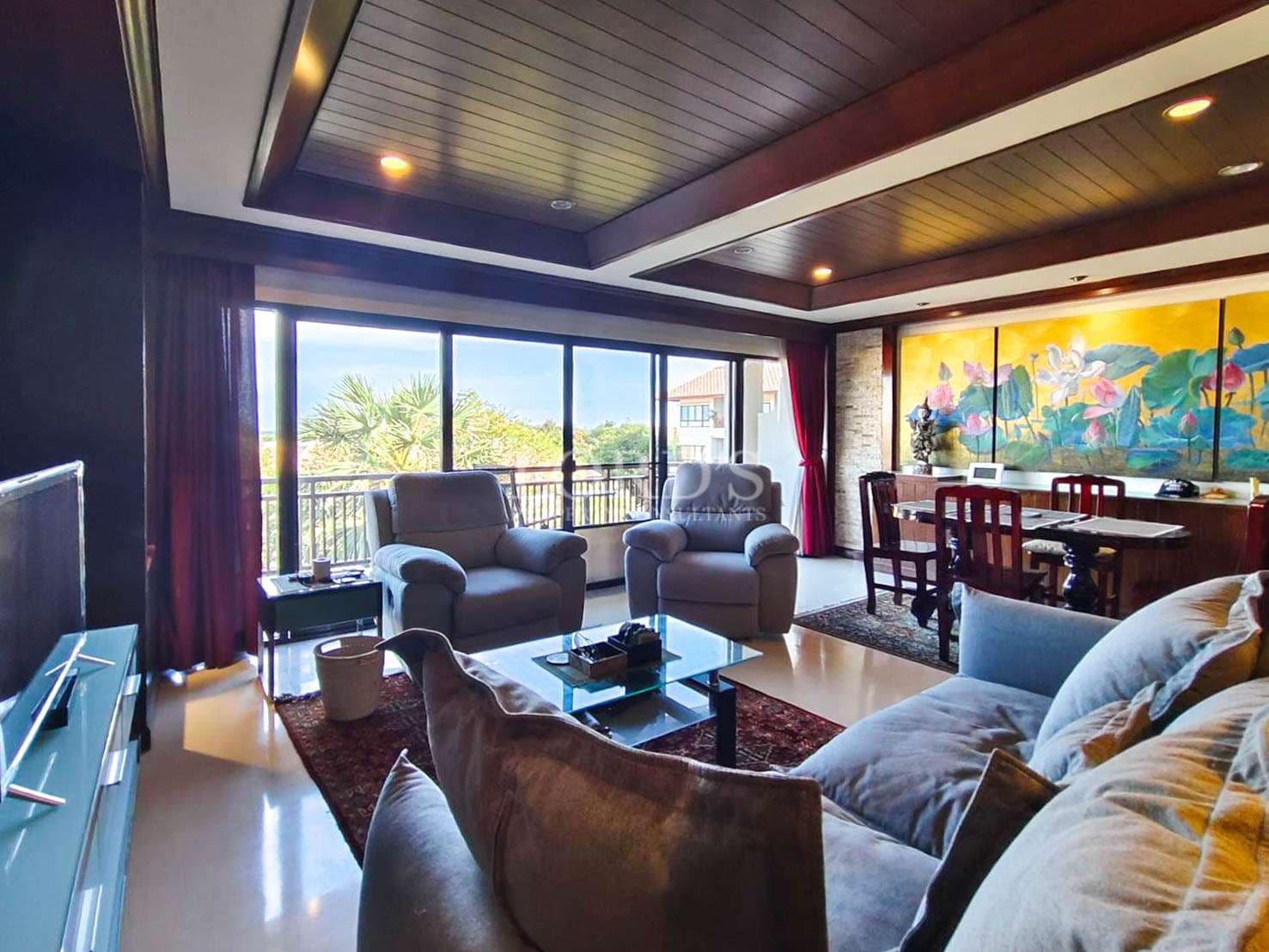 Open-plan living room with large windows, wooden ceiling, modern seating, and balcony view