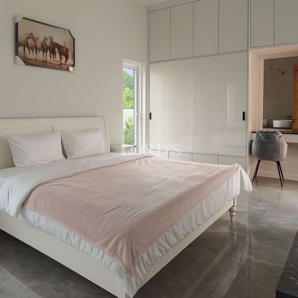 Modern bedroom with white bed frame, built-in wardrobe, and minimalist interior design