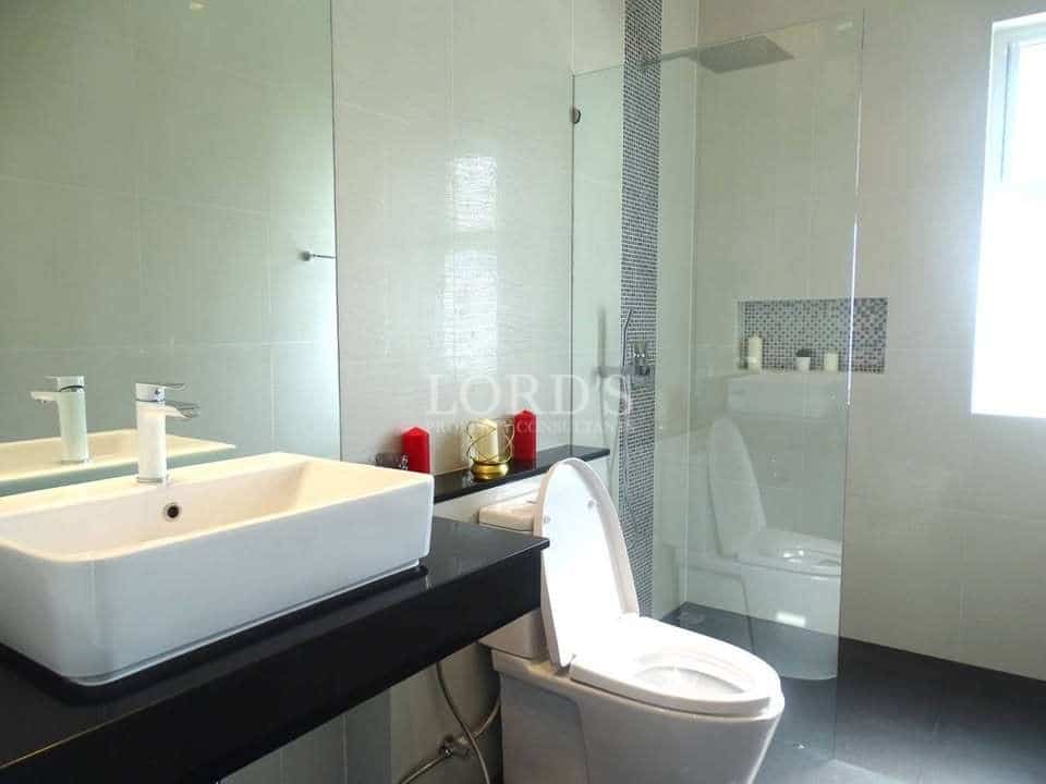 Modern bathroom with vanity sink, toilet, and glass-enclosed walk-in shower