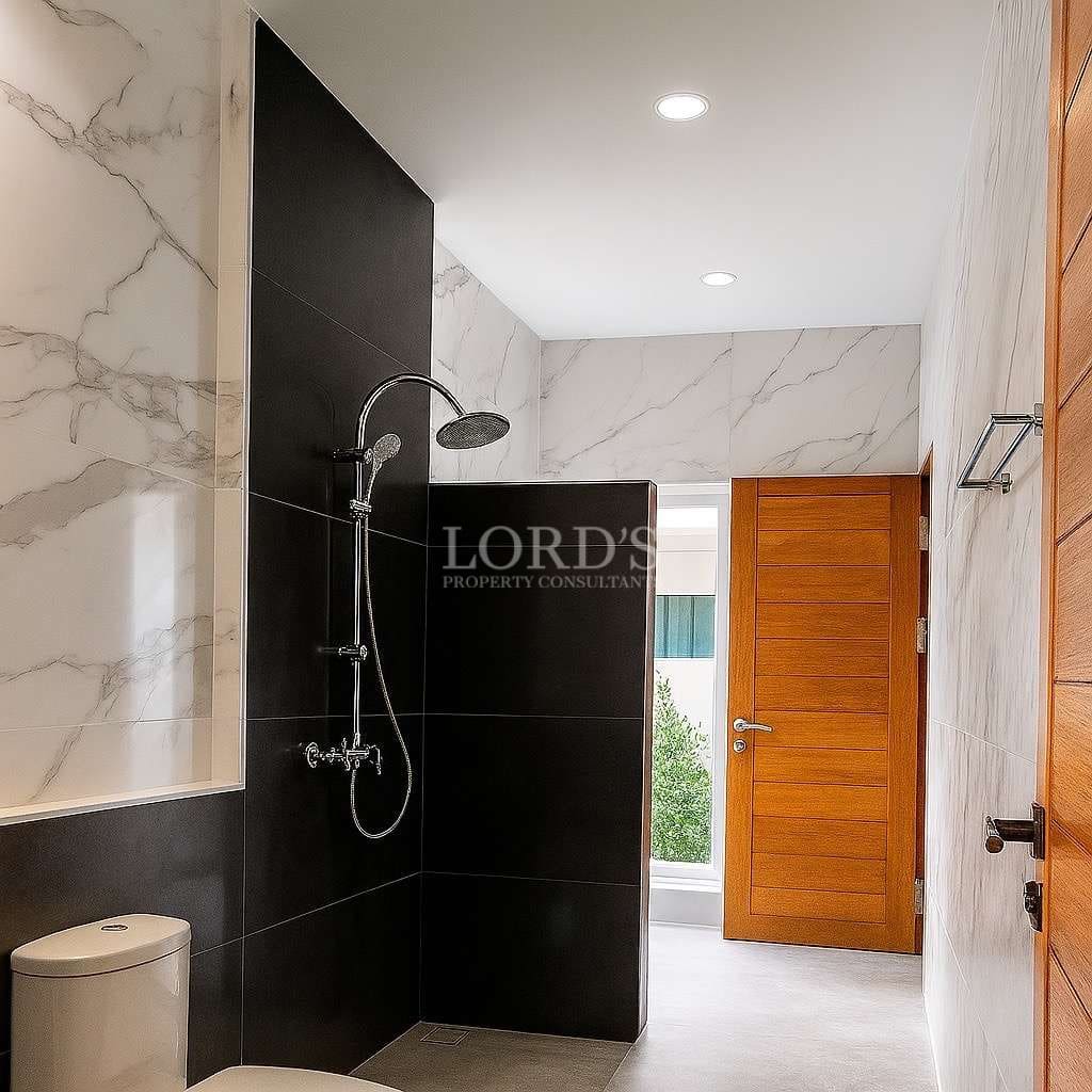 Modern bathroom with walk-in shower, marble-style tiles, and wooden door