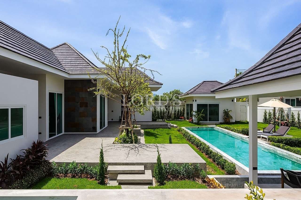 Modern luxury villa courtyard with private swimming pool, garden, and outdoor patio