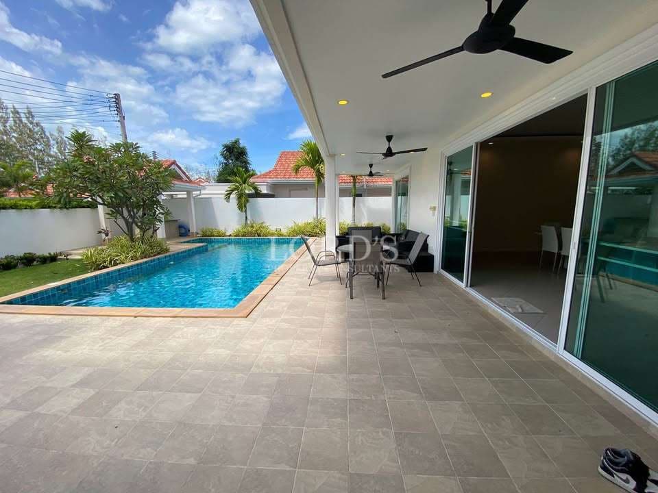 Modern poolside patio with greenery.