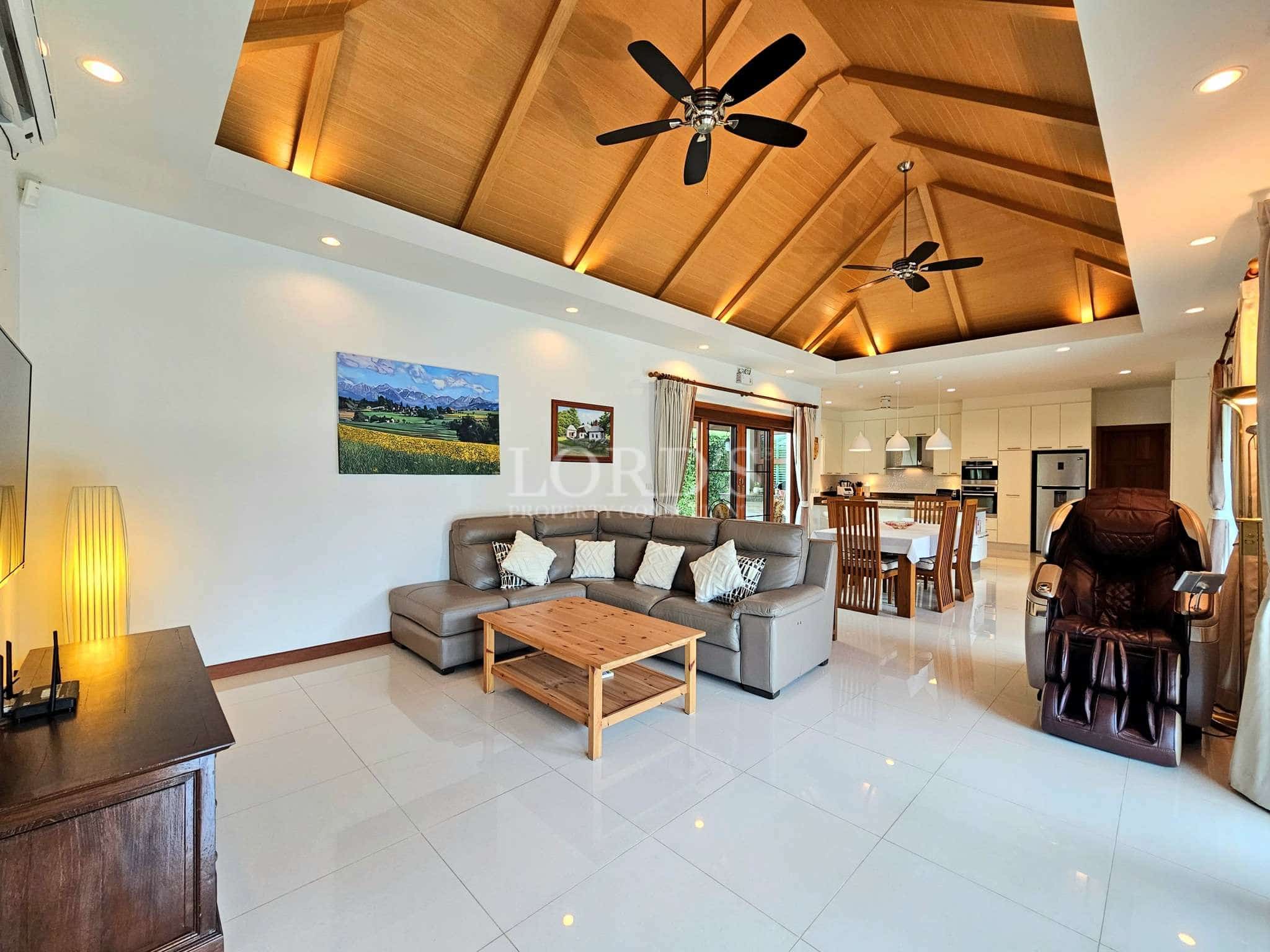 Spacious open-plan living room with high wooden ceiling and modern furniture