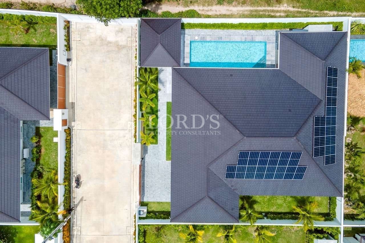 Aerial top view of modern villa with solar panels and private swimming pool