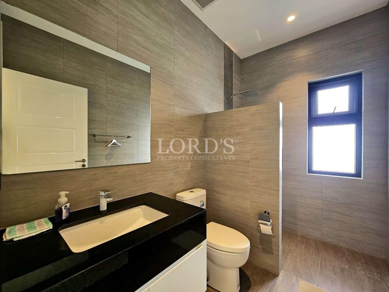 Modern bathroom with walk-in shower, stone wall tiles, and minimalist vanity