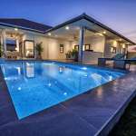 Luxury modern villa with illuminated private swimming pool at dusk