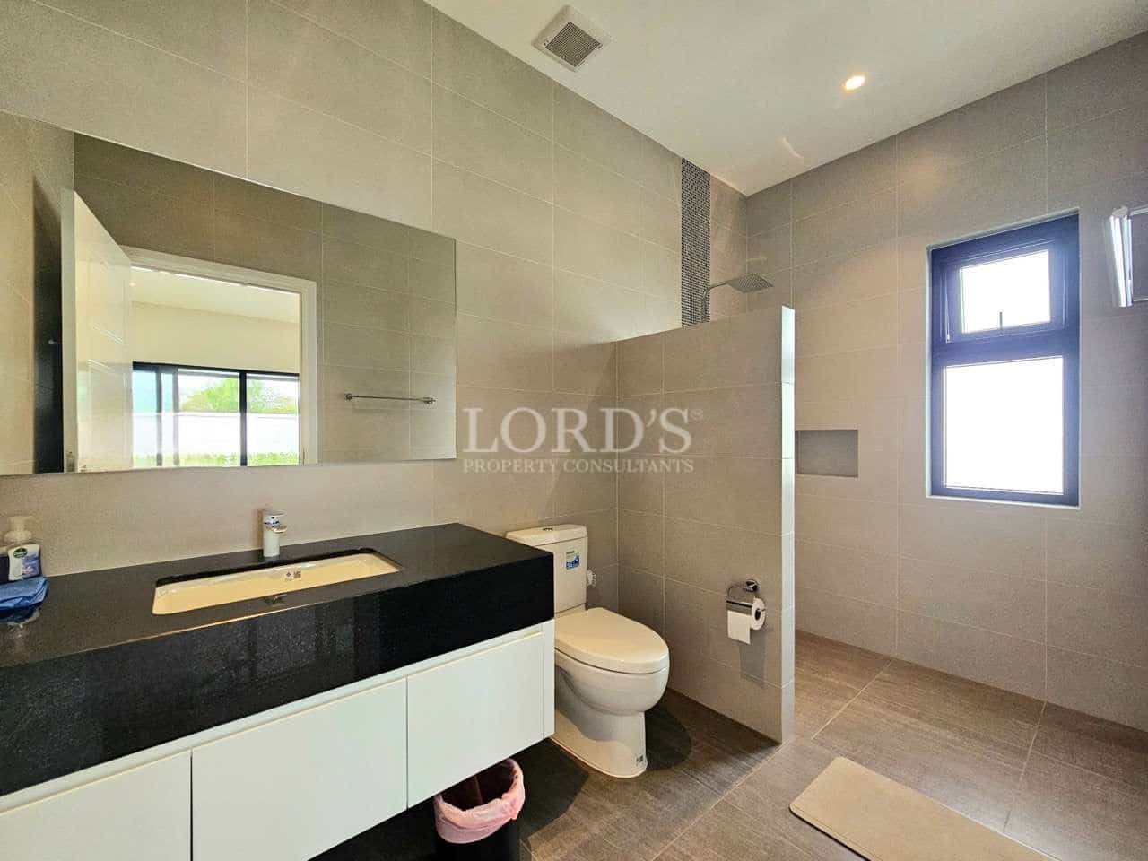 Modern bathroom with walk-in shower, minimalist vanity, and large wall mirror