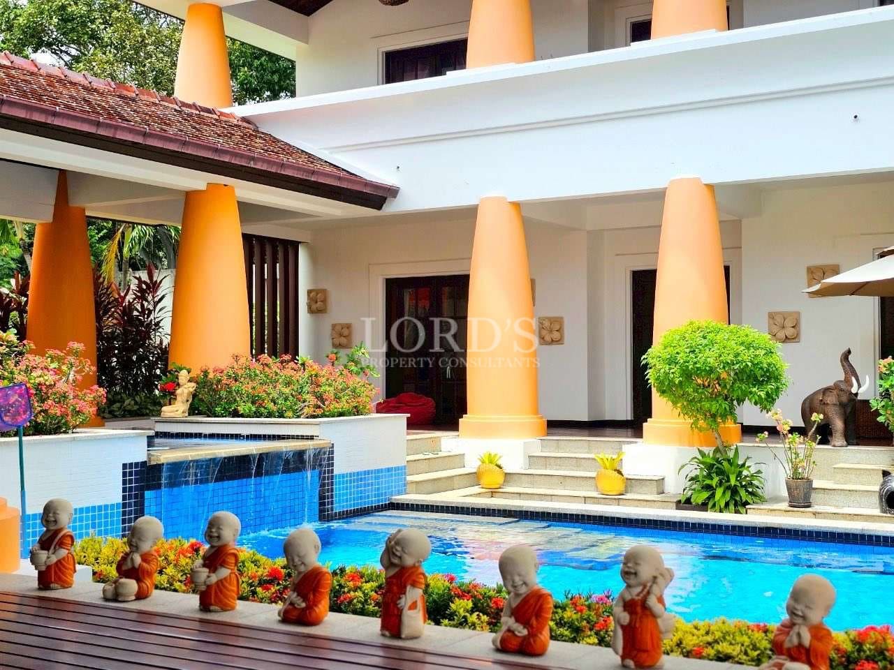 Luxury villa courtyard with a swimming pool, decorative statues, landscaped plants, and elegant columns.