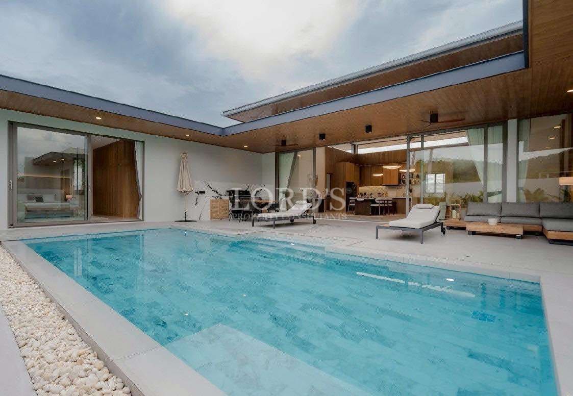 Modern luxury villa with private swimming pool and open-plan indoor-outdoor living area.