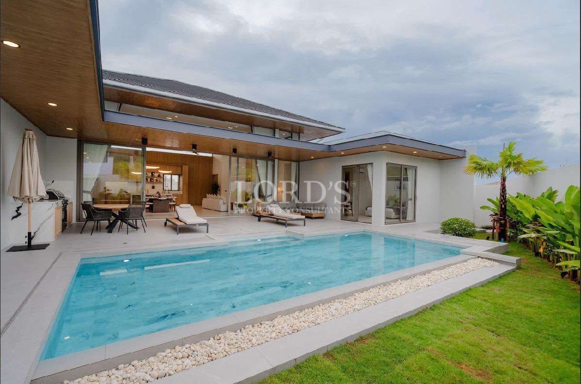 Modern luxury villa with private swimming pool and outdoor lounge area.