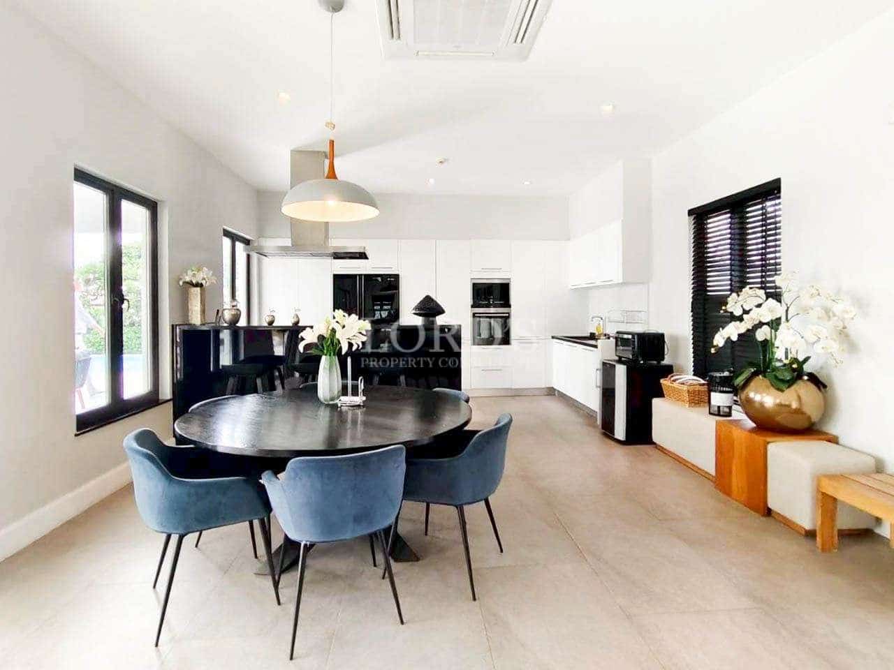 Modern open-plan kitchen and dining area with white cabinetry and stylish dining table