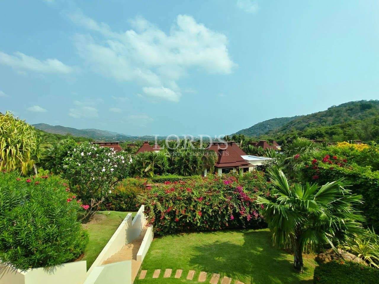 Lush tropical garden with mountain view surrounding a luxury villa in a peaceful residential area.