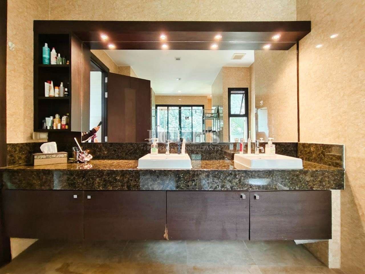 Luxury bathroom with double sink vanity, granite countertop, large mirror, and modern storage cabinets.