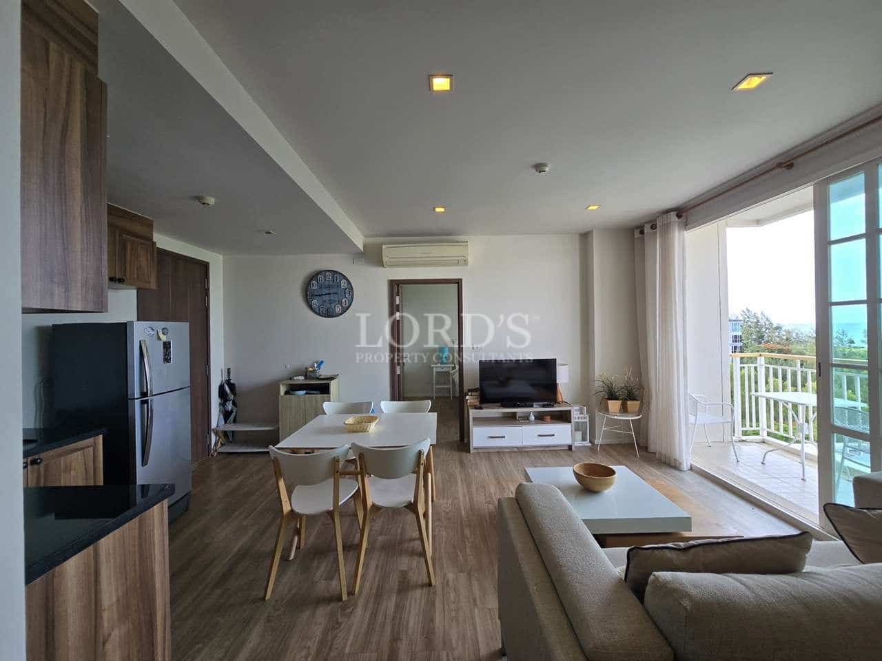 Bright open-plan apartment with living room, dining area, kitchen, and balcony access