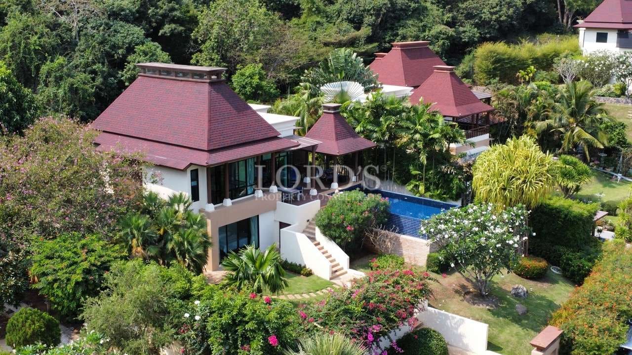 Aerial view of a luxury tropical villa with a private swimming pool surrounded by lush landscaped gardens.