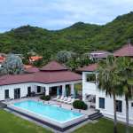 Luxurious villa with pool and greenery.