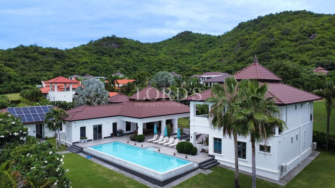 Luxurious villa with pool and greenery.