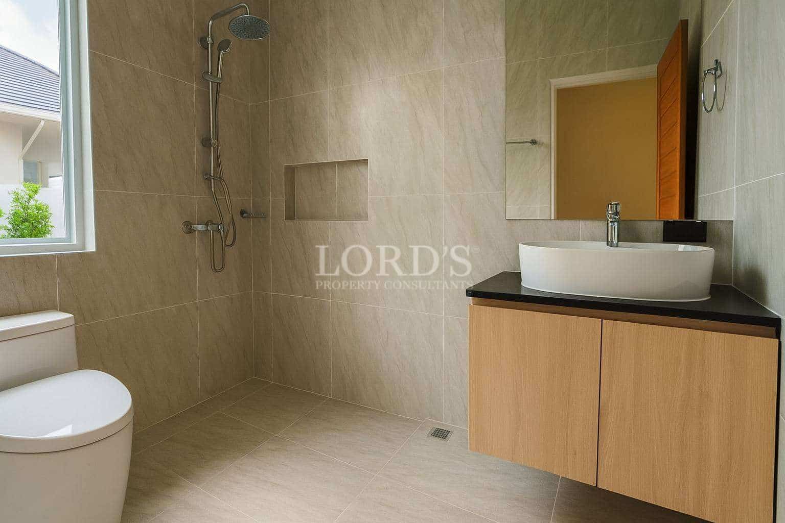 Modern bathroom with walk-in shower, rainfall showerhead, wall niche, floating wooden vanity, and vessel sink.