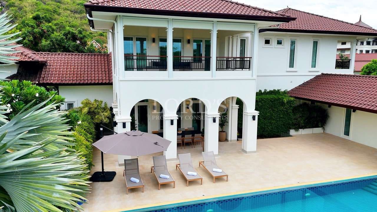Luxury two-story villa with private swimming pool, balcony, and poolside sun loungers.