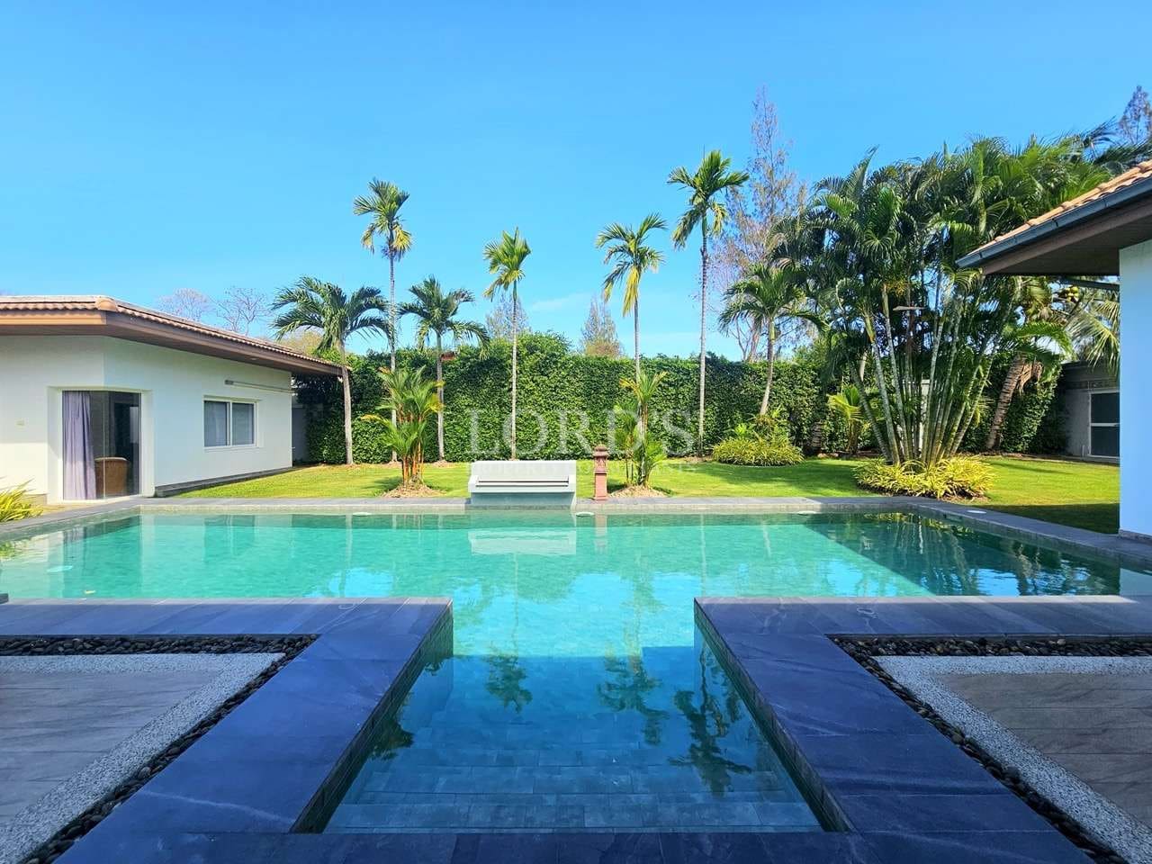 Luxury villa swimming pool with tropical garden, palm trees, clear blue water, and modern outdoor design.