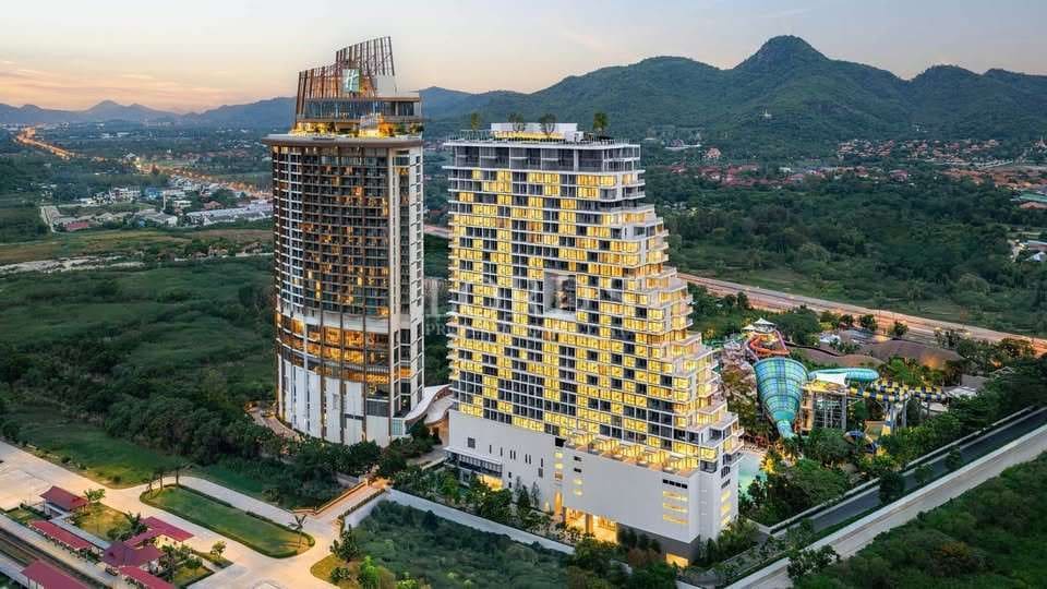 Modern buildings near lush mountains.