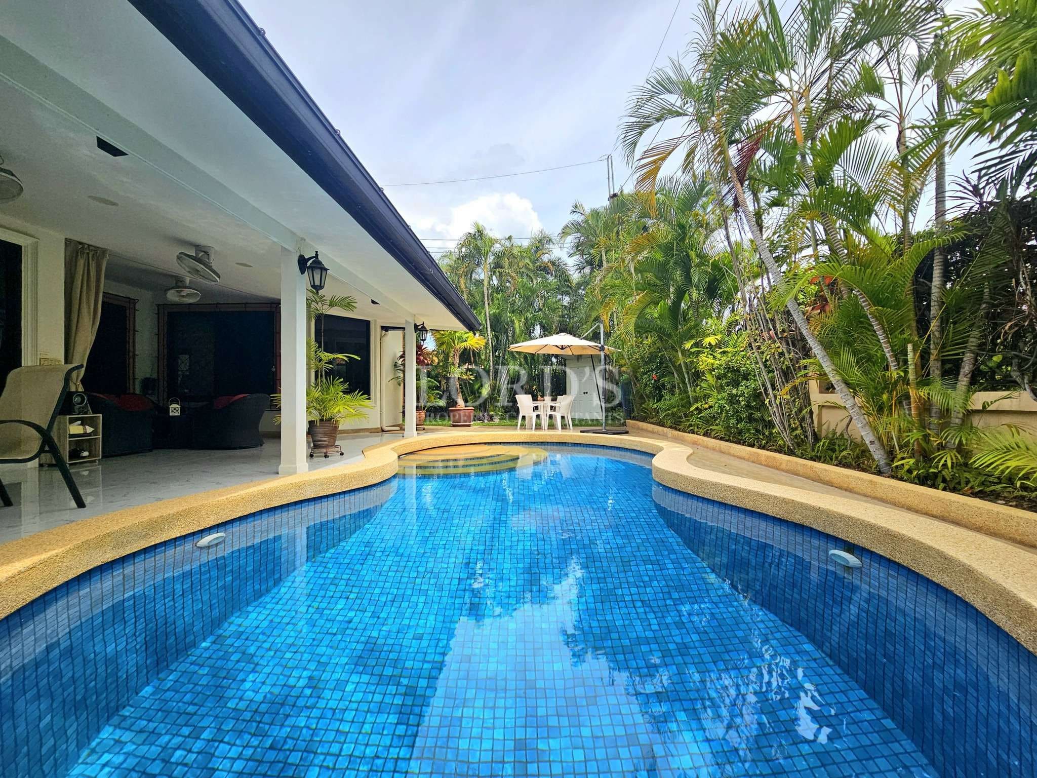 Tropical pool surrounded by greenery.